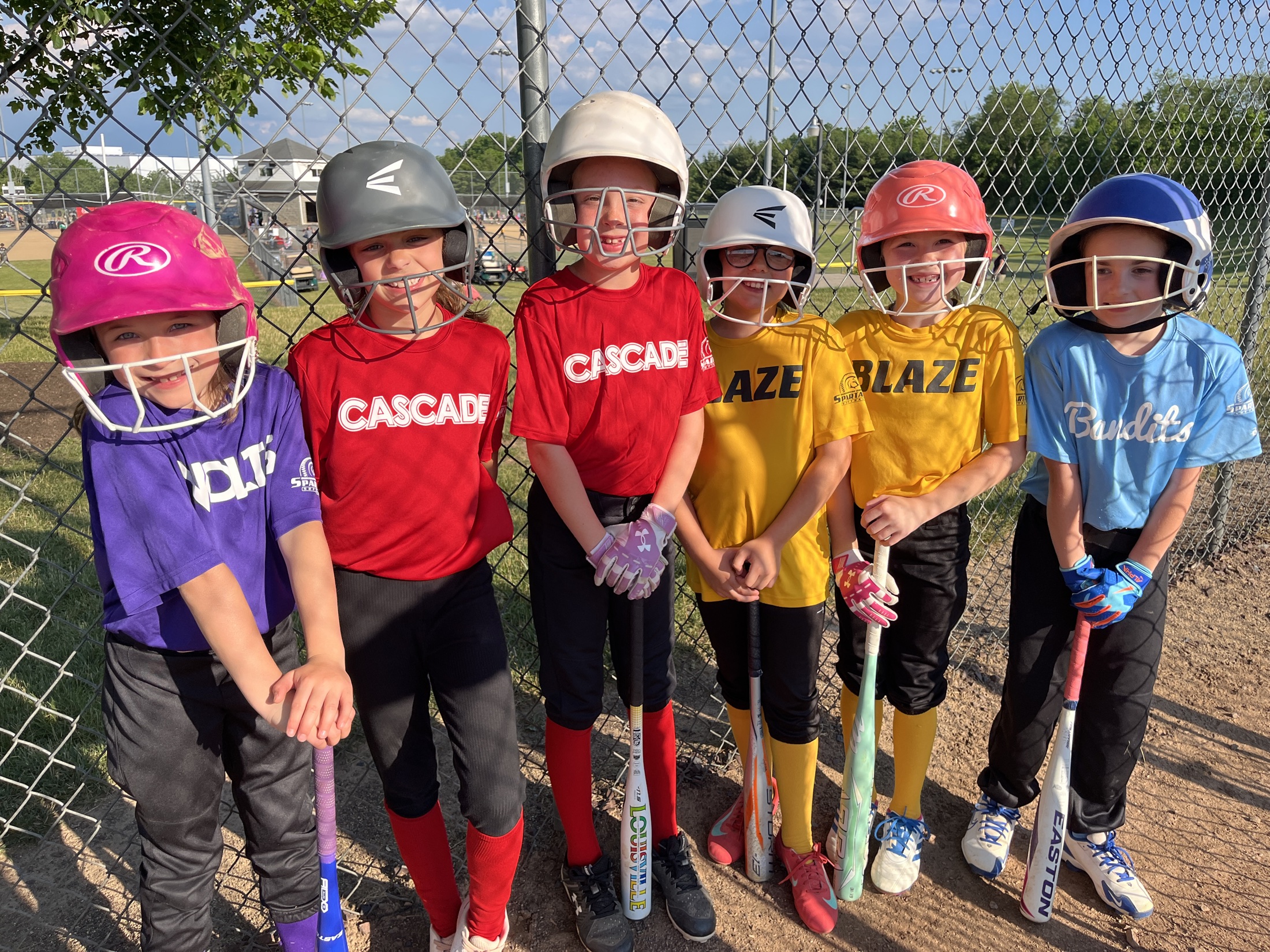 Montgomery youth softball players smiling together at the field